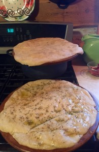 Pizza dough right out of the oven. After I removed it, I spread one with the infused olive oil and the other with pizza sauce.